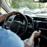 Drivers hands on the steering wheel inside a car