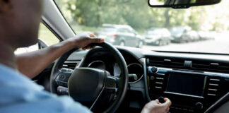 Drivers hands on the steering wheel inside a car