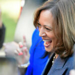 Newsom vs. Harris: California’s Democratic Dilemma A woman smiling and engaging with a crowd at an outdoor event