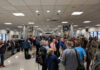Crowd of travelers waiting in an airport terminal near boarding gates