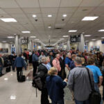 Crowd of travelers waiting in an airport terminal near boarding gates