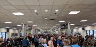 Crowd of travelers waiting in an airport terminal near boarding gates