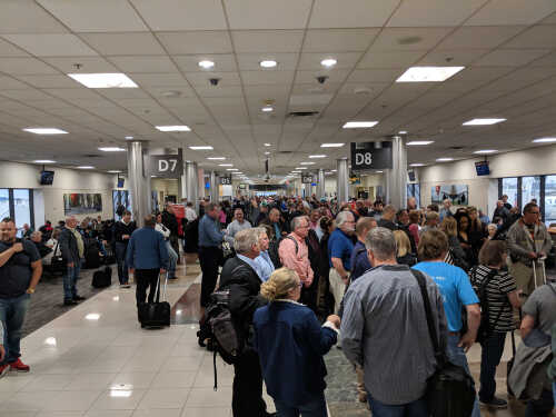 Crowd of travelers waiting in an airport terminal near boarding gates