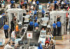 Busy airport security checkpoint with travelers and TSA agents