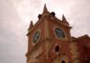 A historic clock tower with a cloudy sky in the background