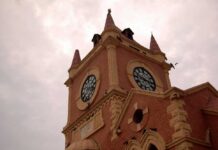 A historic clock tower with a cloudy sky in the background
