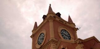 A historic clock tower with a cloudy sky in the background