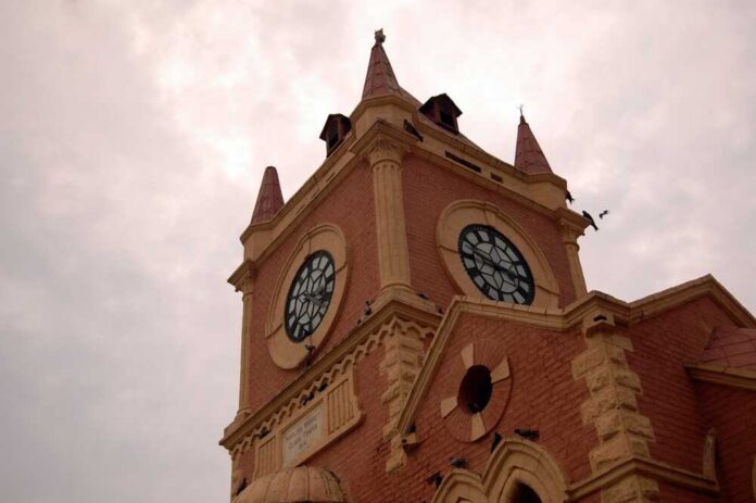 A historic clock tower with a cloudy sky in the background