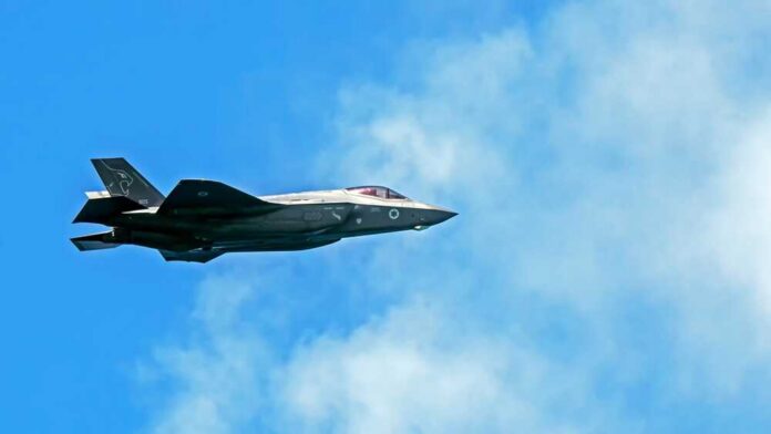 Fighter jet flying against a blue sky with clouds
