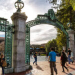 UC Berkeley’s $1M Payout Sparks Campus Uproar Students walking through a historic university gate on a sunny day