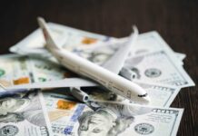 A model airplane placed on top of scattered dollar bills
