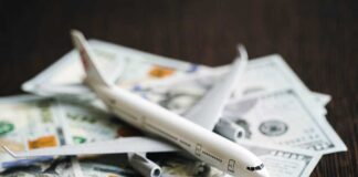 A model airplane placed on top of scattered dollar bills