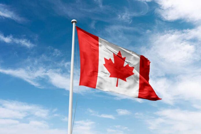 shutterstock_2496996631.jpg Canadian flag waving against a blue sky