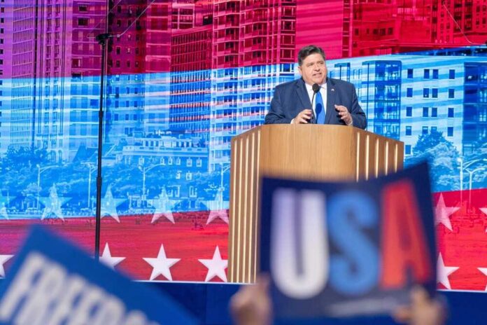 shutterstock_2507619993.jpg A politician delivering a speech at a podium with a backdrop of the USA flag