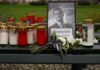 Assassination Sparks RADICAL New Campus Speech Law Memorial setup with candles, flowers, and a framed photograph