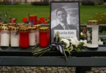 Memorial setup with candles, flowers, and a framed photograph