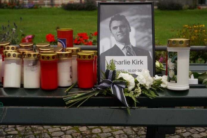 Memorial setup with candles, flowers, and a framed photograph
