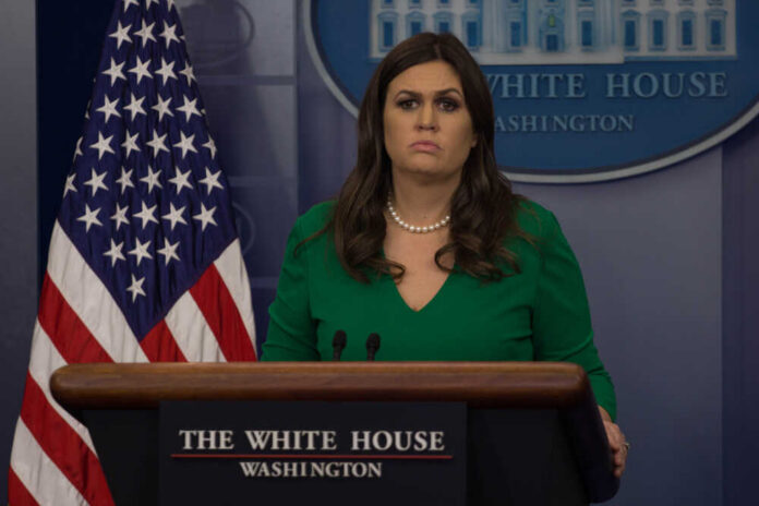 shutterstock_744405031.jpg A government official at a press briefing in front of the American flag