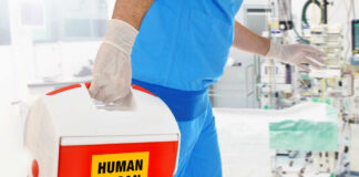 Healthcare professional carrying a cooler labeled 'HUMAN ORGAN'