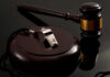 A silver whistle and a gavel on a reflective surface
