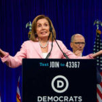 A female politician speaking at a podium with Democratic Party branding