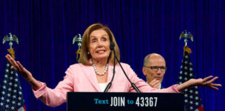 A female politician speaking at a podium with Democratic Party branding