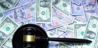 A gavel with the word 'TAX' on it placed on a background of US dollar bills