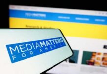 Smartphone displaying Media Matters for America logo in front of a website