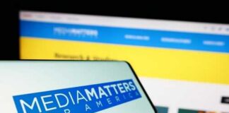 Smartphone displaying Media Matters for America logo in front of a website