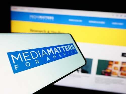 shutterstock_2396908699.jpg Smartphone displaying Media Matters for America logo in front of a website