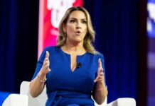 A woman in a blue dress speaking passionately at a conference