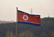 North Korean flag waving against a mountainous backdrop