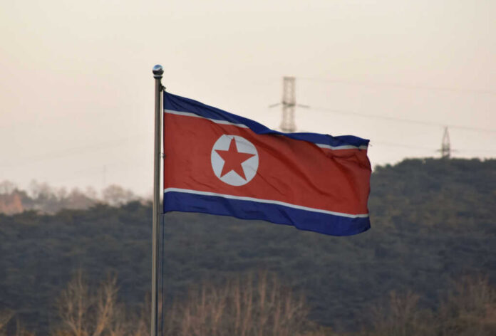North Korean flag waving against a mountainous backdrop