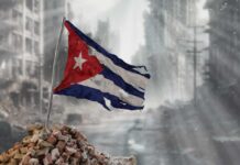 Tattered Cuban flag waving over a pile of rubble in a devastated urban landscape