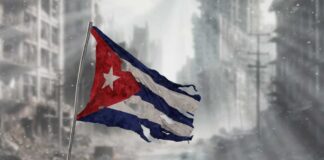Tattered Cuban flag waving over a pile of rubble in a devastated urban landscape