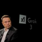 Elon Musk speaking during a technology event with a dark background