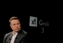 Elon Musk speaking during a technology event with a dark background