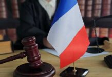 Court Crushes Vague Security Claims — Stunning! A gavel and a small French flag on a desk in a courtroom setting