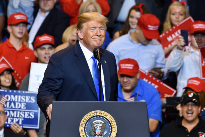 Wilkes-barre,,Pa,-,August,2,,2018:,President,Trump,Gestures,With A speaker at a political rally smiling in front of an enthusiastic crowd wearing red hats
