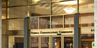 Entrance of the Federal Communications Commission building with glass doors and signage