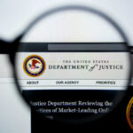 Close-up view of the Department of Justice website through a magnifying glass