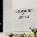 Sign on the exterior wall of the Department of Justice building