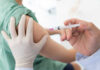 A healthcare professional administering a vaccine to a patient's arm