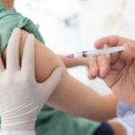 A healthcare professional administering a vaccine to a patient's arm