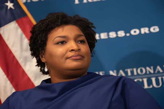 A political figure speaking at a podium with a blue backdrop