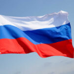 Nuclear Strike Rehearsals RATTLE NATO’s Borders Russian flag waving against a clear blue sky