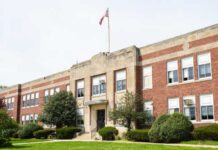 Exterior view of a brick school building with an American flag