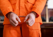 Safeguards Shattered: Predator Trolled UK Classrooms A person in an orange jumpsuit with handcuffs