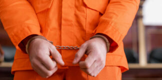 A person in an orange jumpsuit with handcuffs