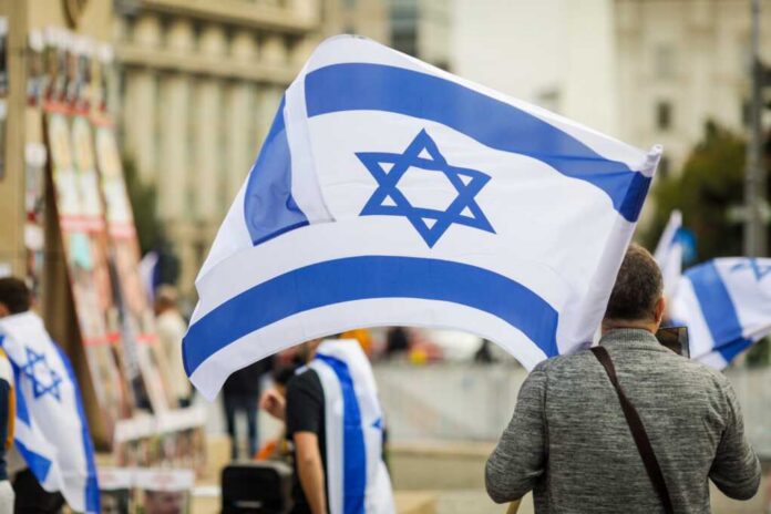 Person holding an Israeli flag at a public demonstration